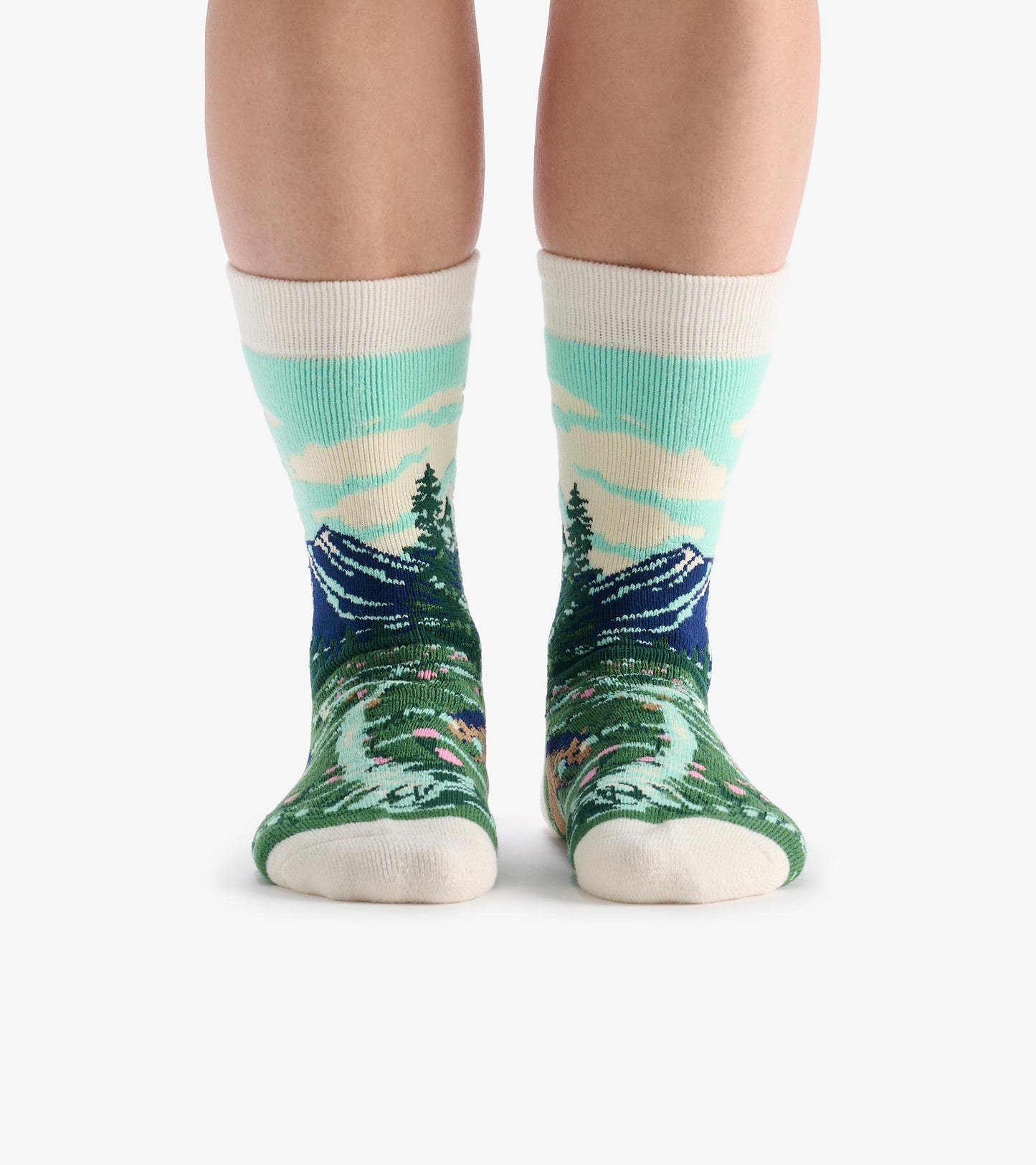 Cozy socks featuring a mountain and forest pattern in green, blue, and cream, designed for comfort and warmth.