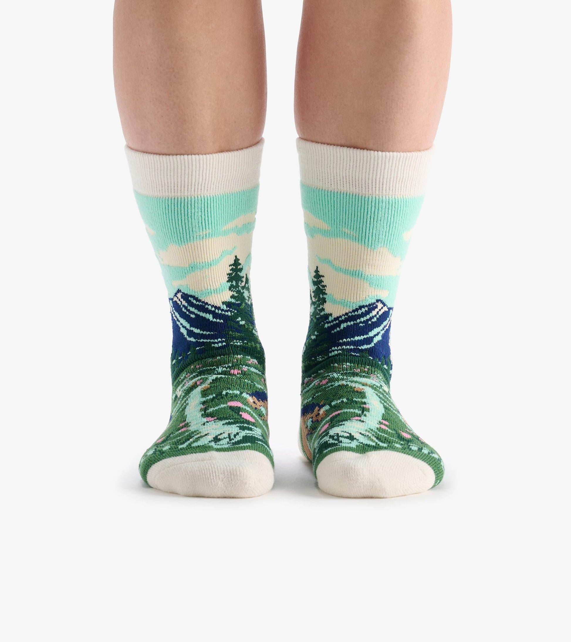 Cozy socks featuring a mountain and forest pattern in green, blue, and cream, designed for comfort and warmth.