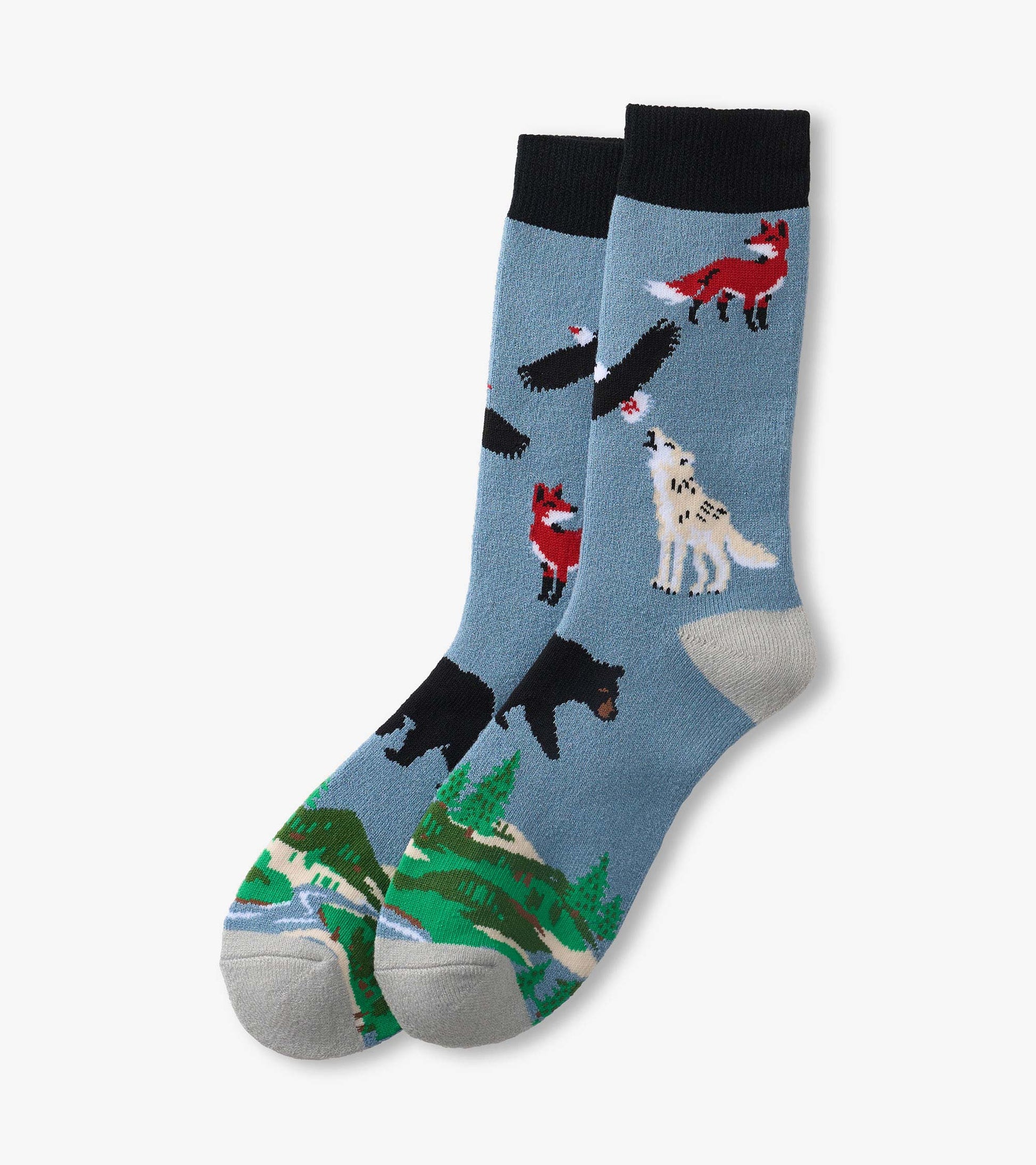 Pair of blue crew socks with black cuffs, featuring fox, bear, wolf, and forest landscape patterns