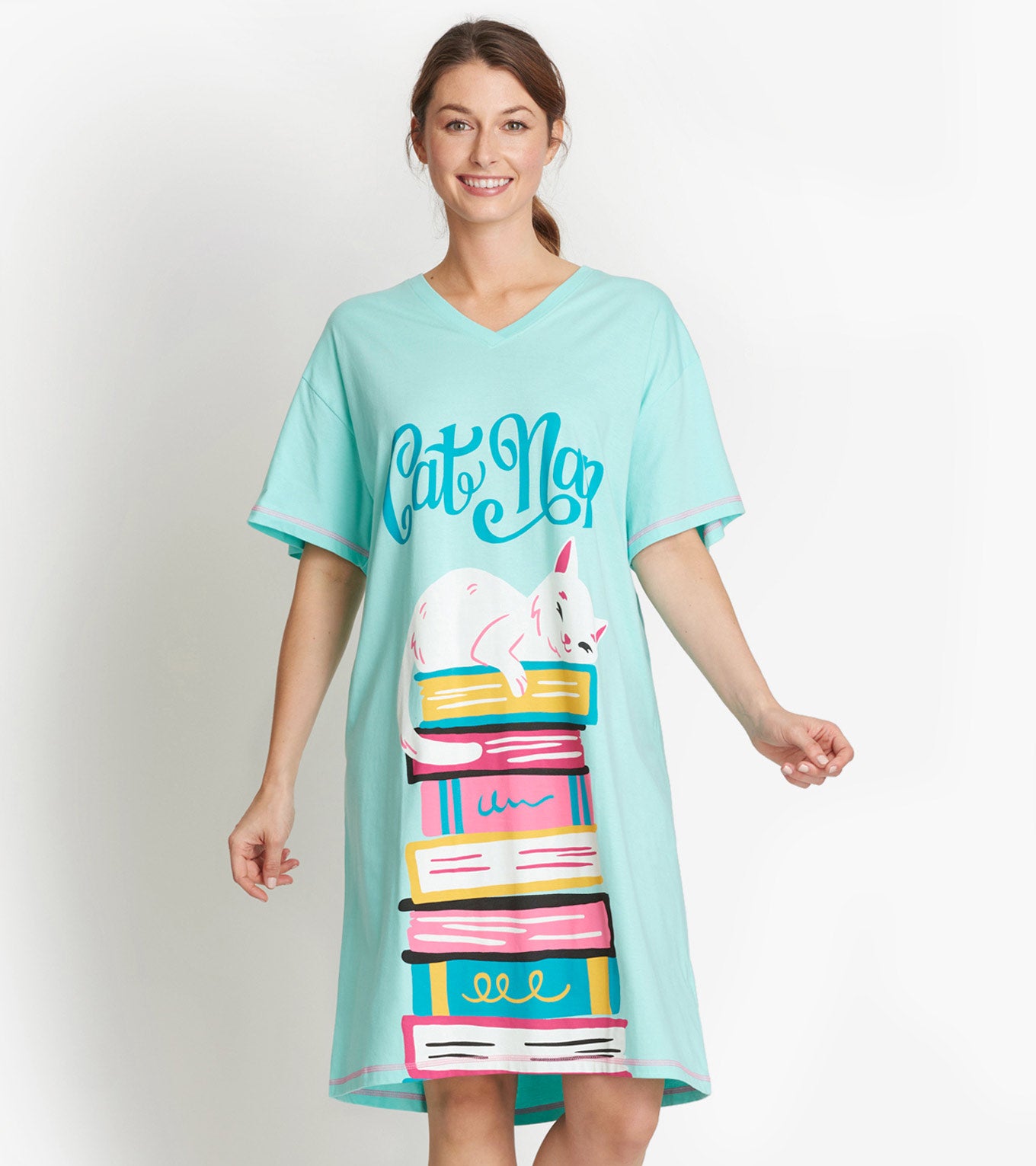 Woman modeling aqua V-neck sleepshirt with Cat Nap text and white cat on a stack of colorful books