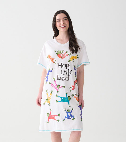 Woman wearing white V-neck sleepshirt with colorful frogs in pajamas and 'Hop into bed' text