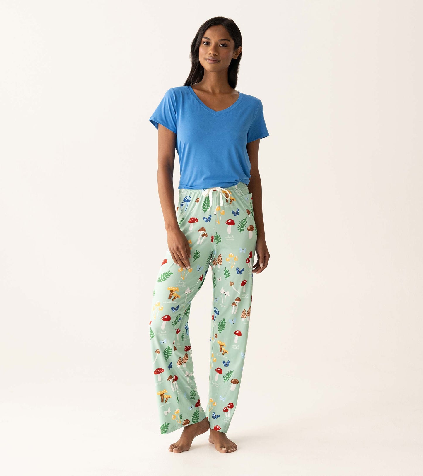 Woman wearing a blue V-neck T-shirt and mint green mushroom-print pajama pants, front view