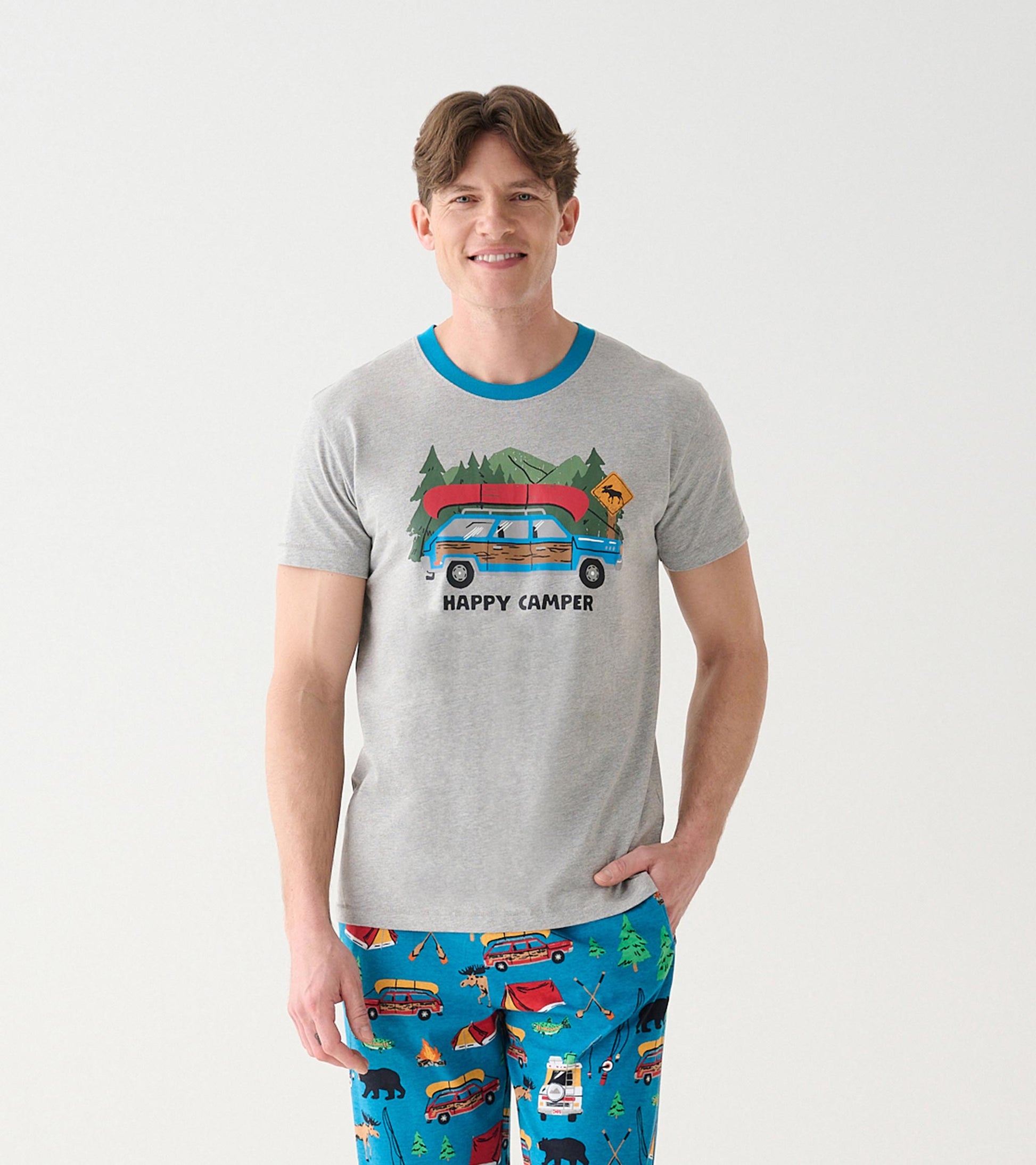 Front view of heather gray men's camping T-shirt with blue neck and station wagon graphic worn with blue print pants