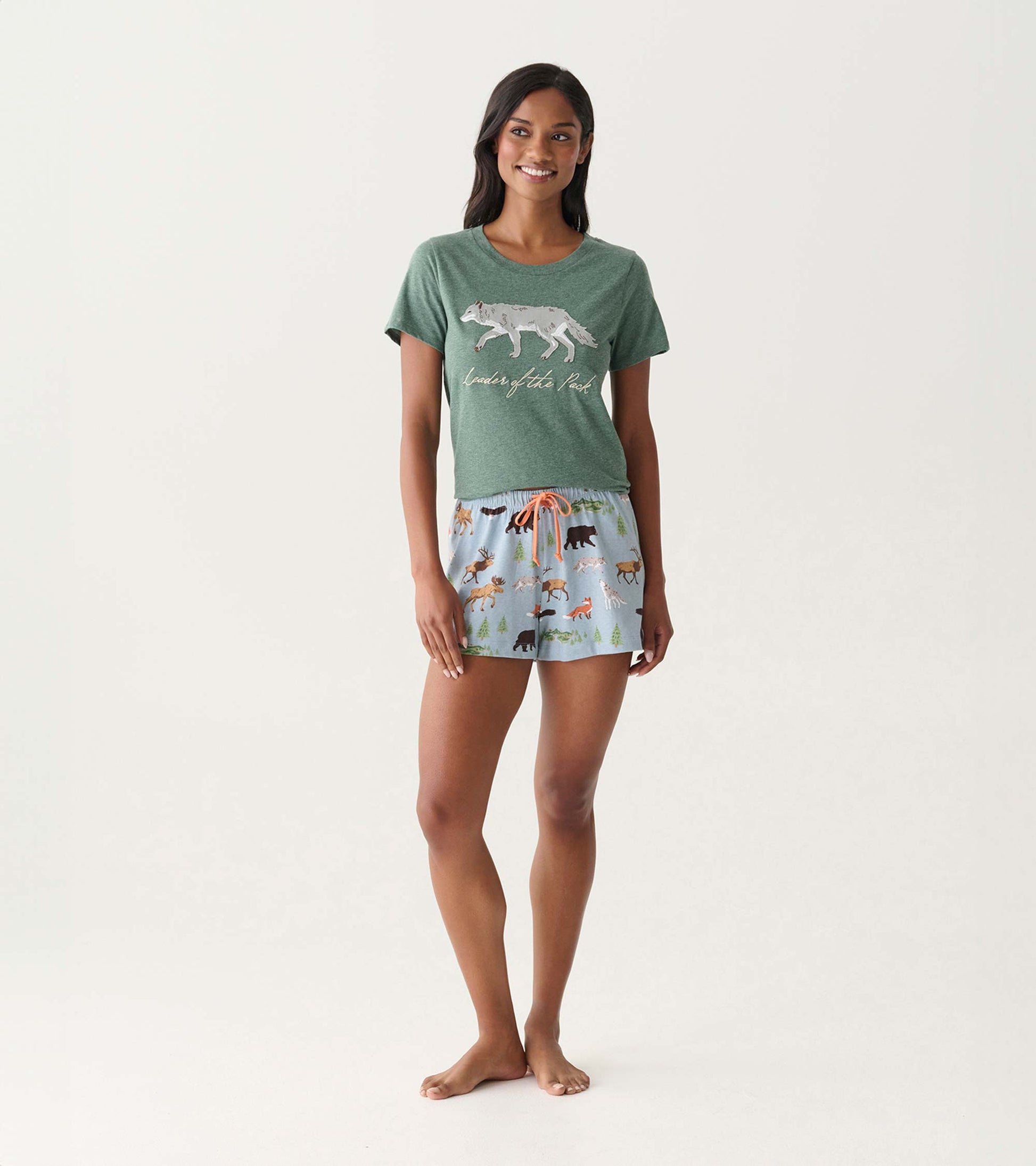 Green short-sleeve pajama T-shirt with wolf graphic and “leader of the pack” text, shown on model with printed shorts.