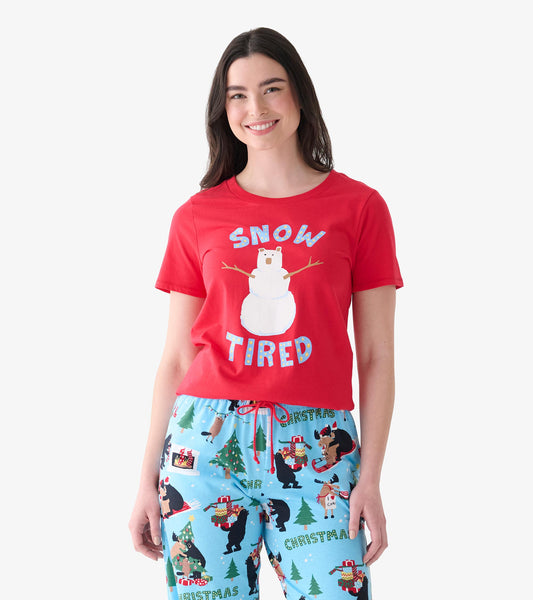 Model wearing red pajama T-shirt with bear snowman graphic and Snow Tired text, paired with light blue printed pants