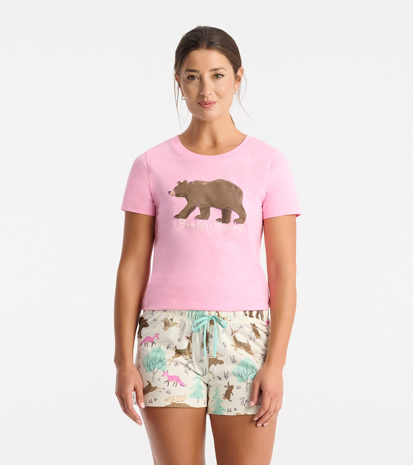Pink short-sleeve pajama T-shirt with bear graphic and script text, paired with printed pajama shorts.