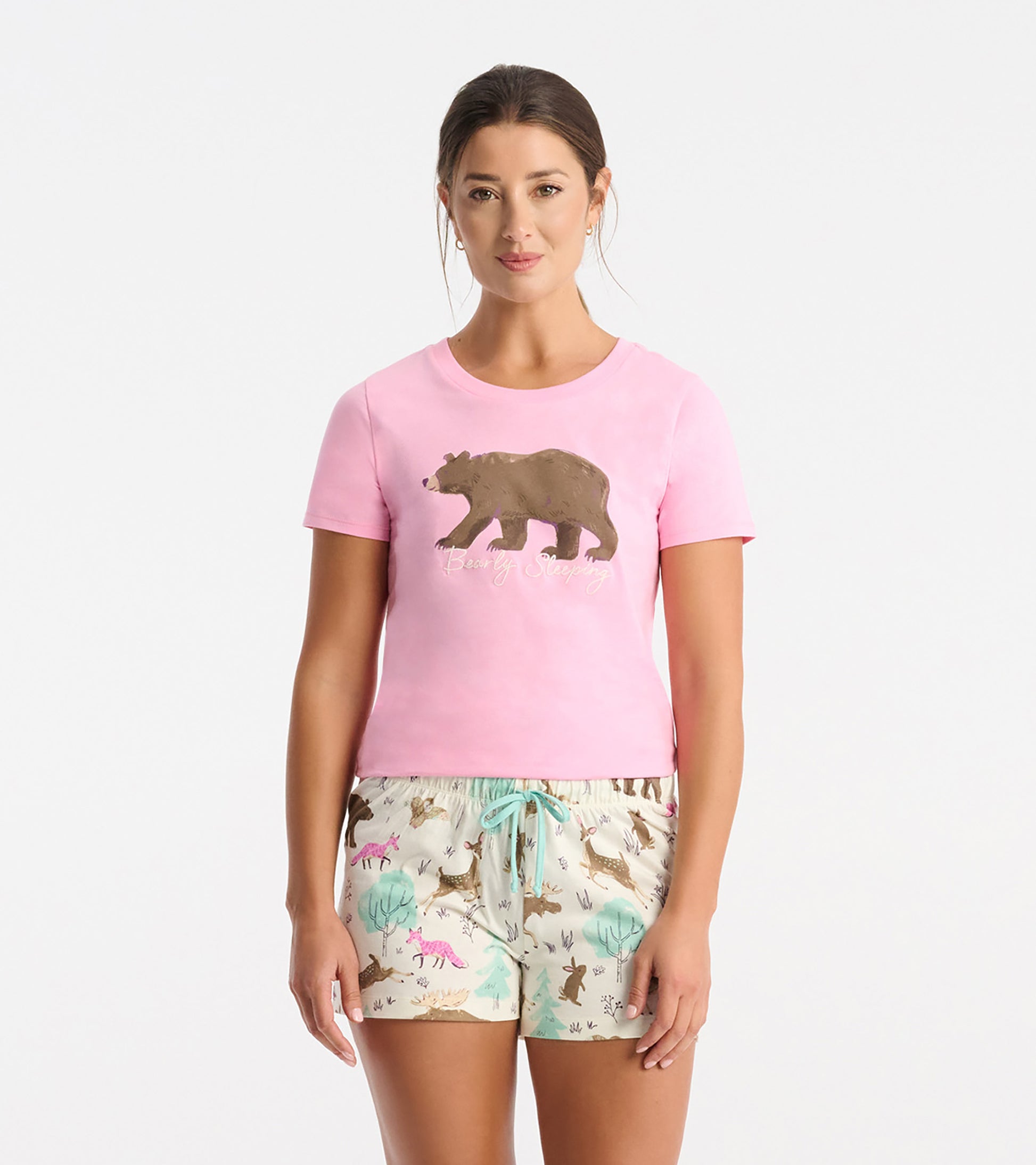 Pink short-sleeve pajama T-shirt with bear graphic and script text, paired with printed pajama shorts.