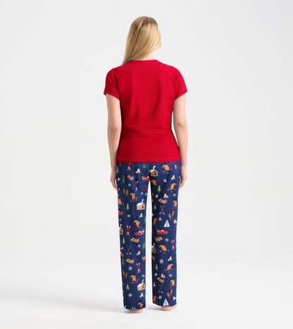 Red short-sleeve pajama t-shirt paired with navy pants featuring a winter-themed print of animals and cabins.
