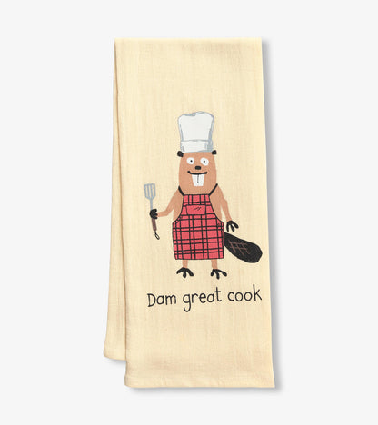 Beige tea towel featuring a cartoon beaver in a chef's hat and plaid apron, holding a spatula with "Dam great cook" text.