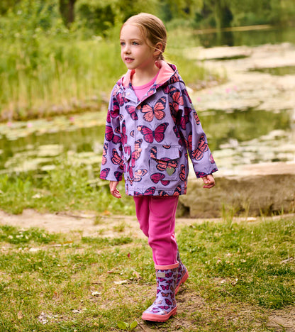 Girl wearing a lavender butterfly-print hooded rain jacket with pink lining and snap front, front view