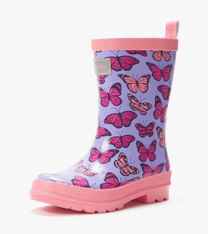 Purple kids rain boot with pink butterfly print and pink sole, trim, and pull tab