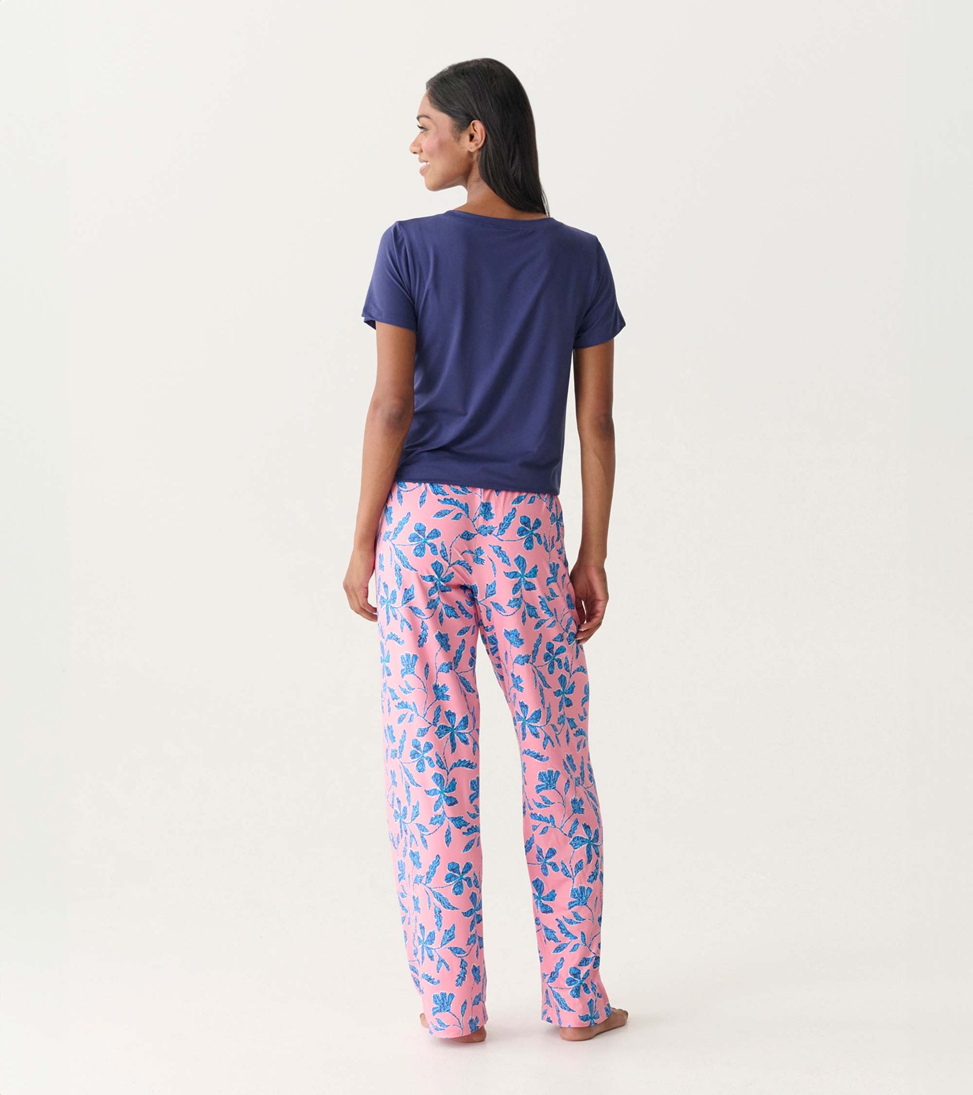 Back view of pink pajama pants with blue floral print, paired with a navy short-sleeve top.