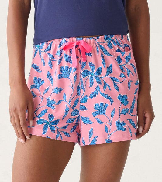 Pink pajama shorts with blue floral print, elastic waistband, and front drawstring, shown on a model.