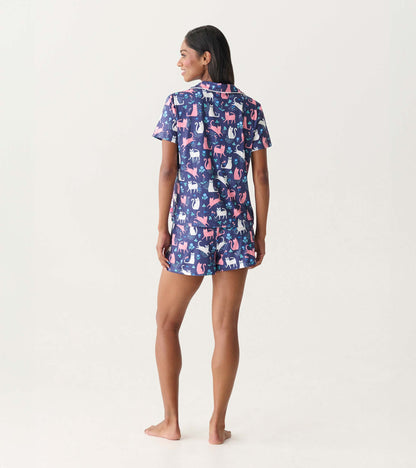 Back view of a navy short-sleeve pajama set with pink and white cat print and matching shorts