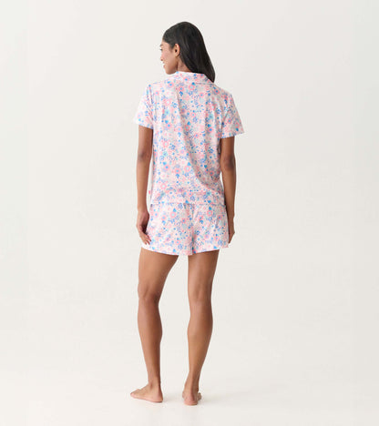 Back view of a pink and blue floral short-sleeve pajama set with button-down top and shorts