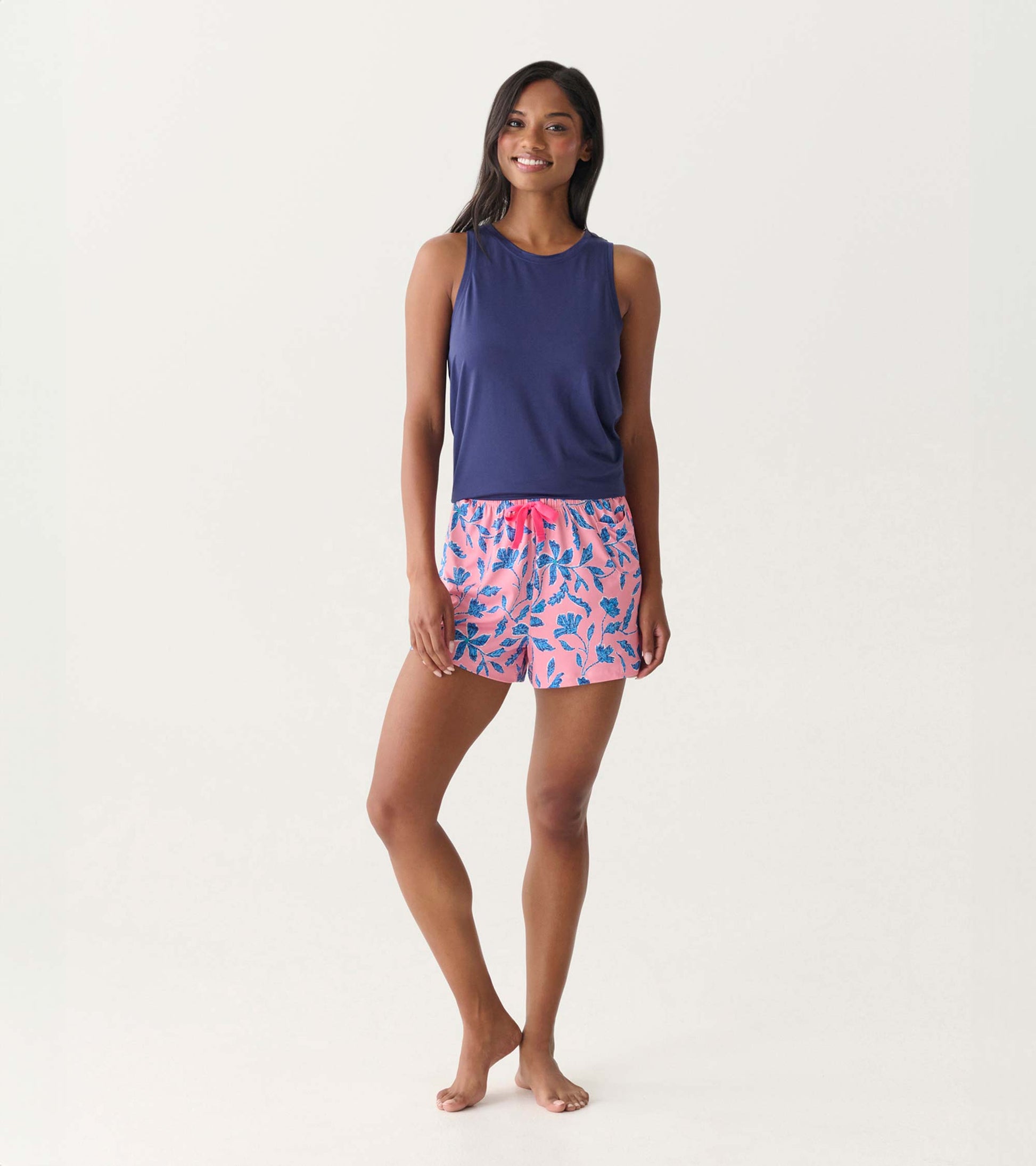 Front view of a navy scoop neck tank top on a model, sleeveless and fitted with a smooth knit finish.