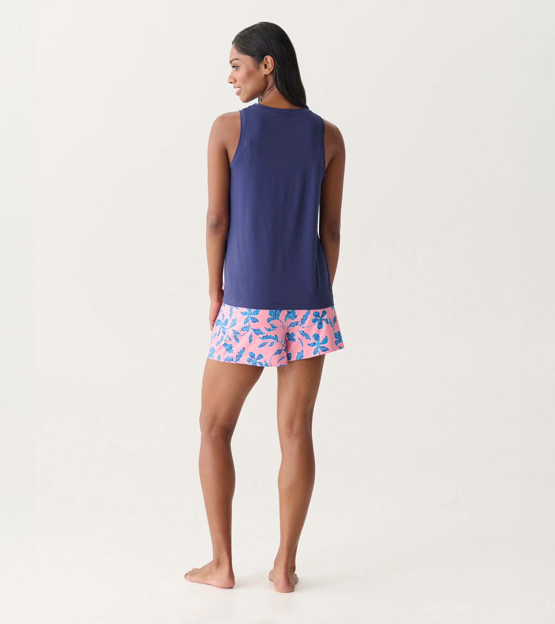 Back view of a navy scoop neck tank top on a model, paired with pink floral shorts.