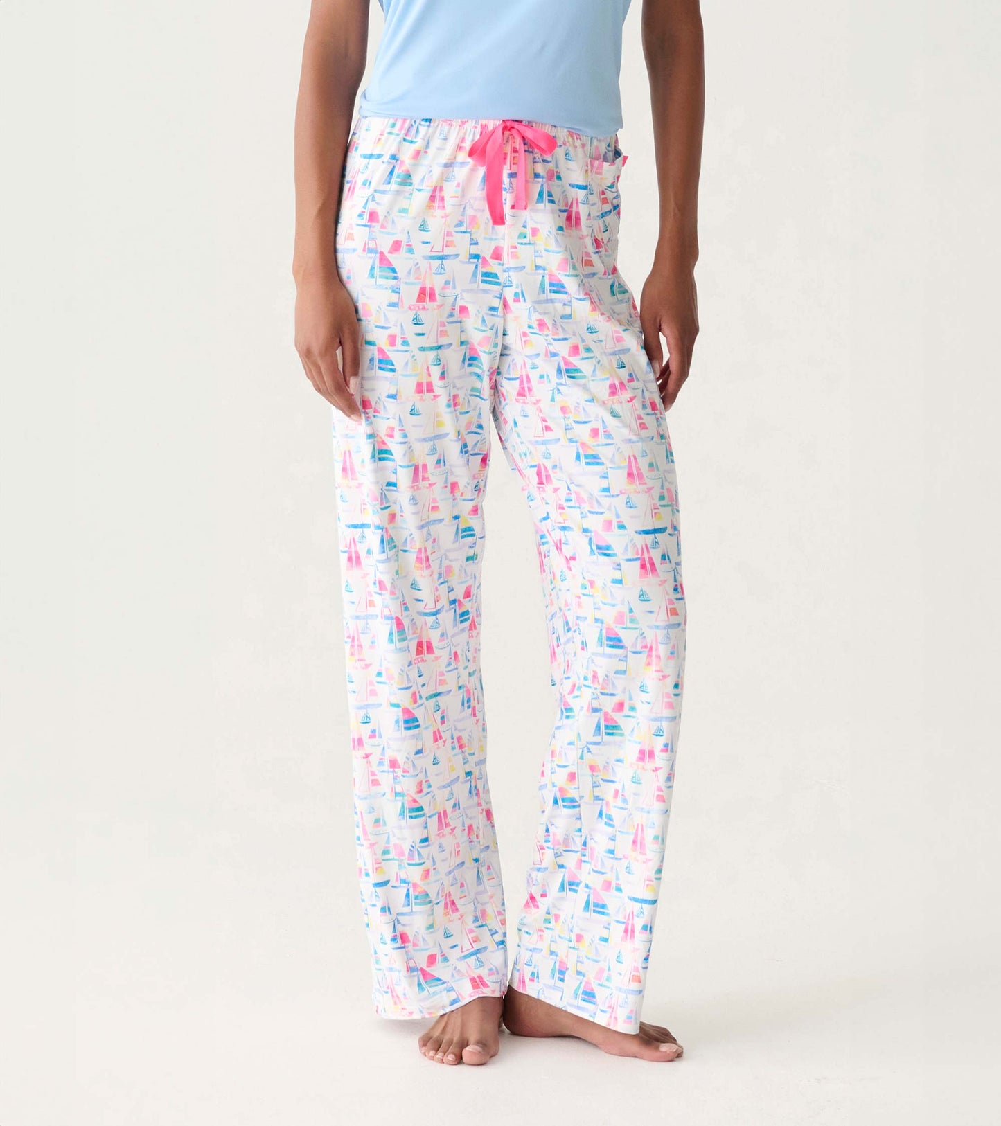 Women's white pajama pants with colorful sailboat print and pink drawstring waistband, front view
