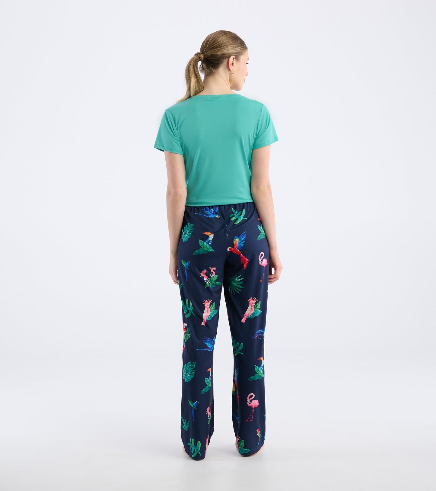 Navy pajama pants featuring a colorful tropical bird and leaf pattern, made from soft polyknit material.