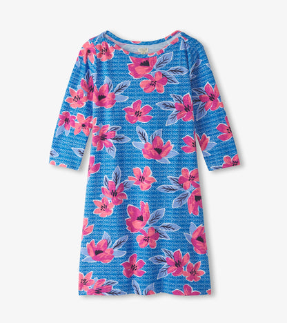 Blue dress with bold pink and purple floral pattern, featuring a bateau neckline and three-quarter sleeves.