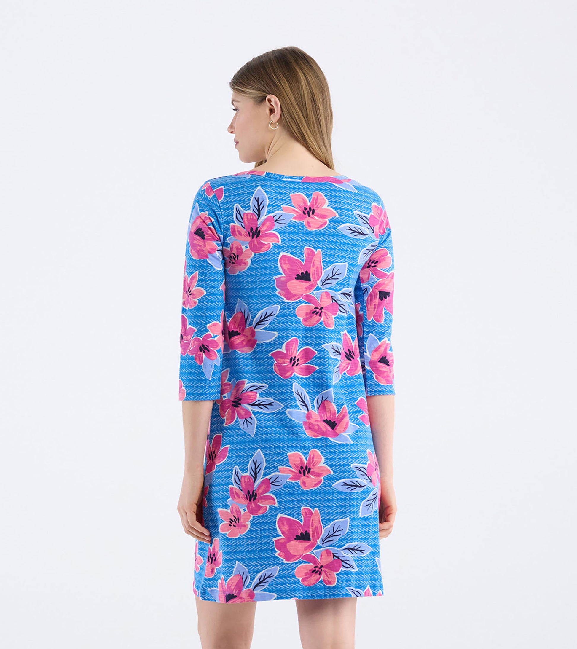 Back view of a women's bateau dress featuring a bold floral pattern in pink and blue on a textured background.