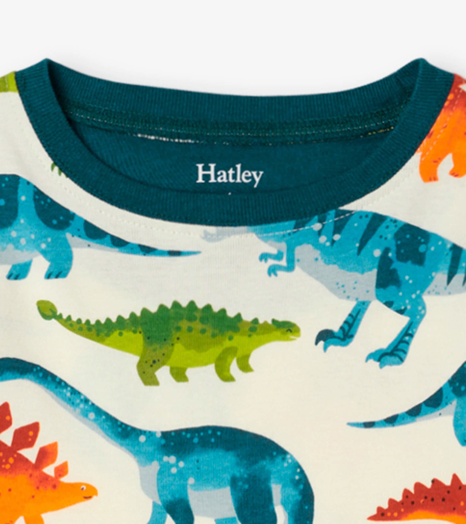 Organic cotton kids' pajama set featuring colorful dinosaur prints and a teal crew neck.