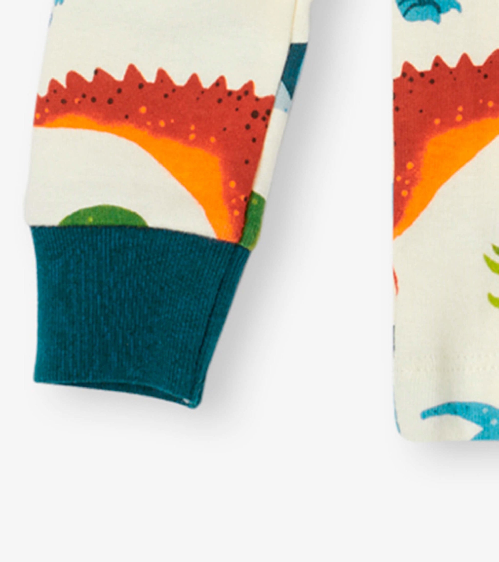Organic cotton kids pajama set featuring colorful dinosaur patterns and teal cuffs. Ideal for comfortable sleepwear.
