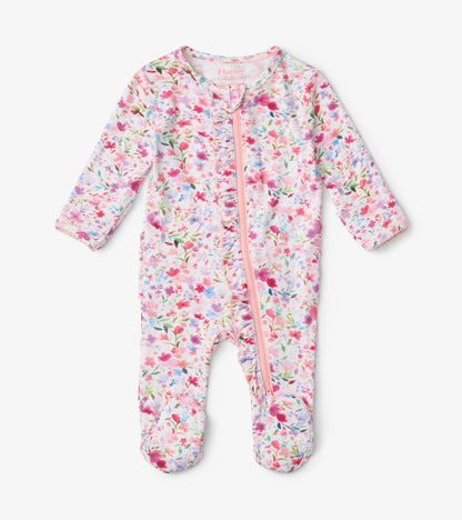 Floral-patterned footed sleeper in pastel colors with ruffle details and a front zipper, suitable for babies.