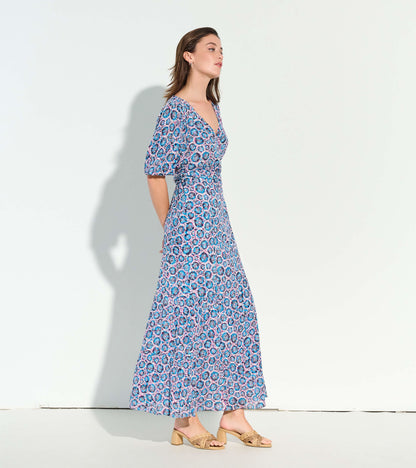 Maxi dress featuring a sundial mandala pattern in blue, pink, and white, with a v-neck and puff sleeves.