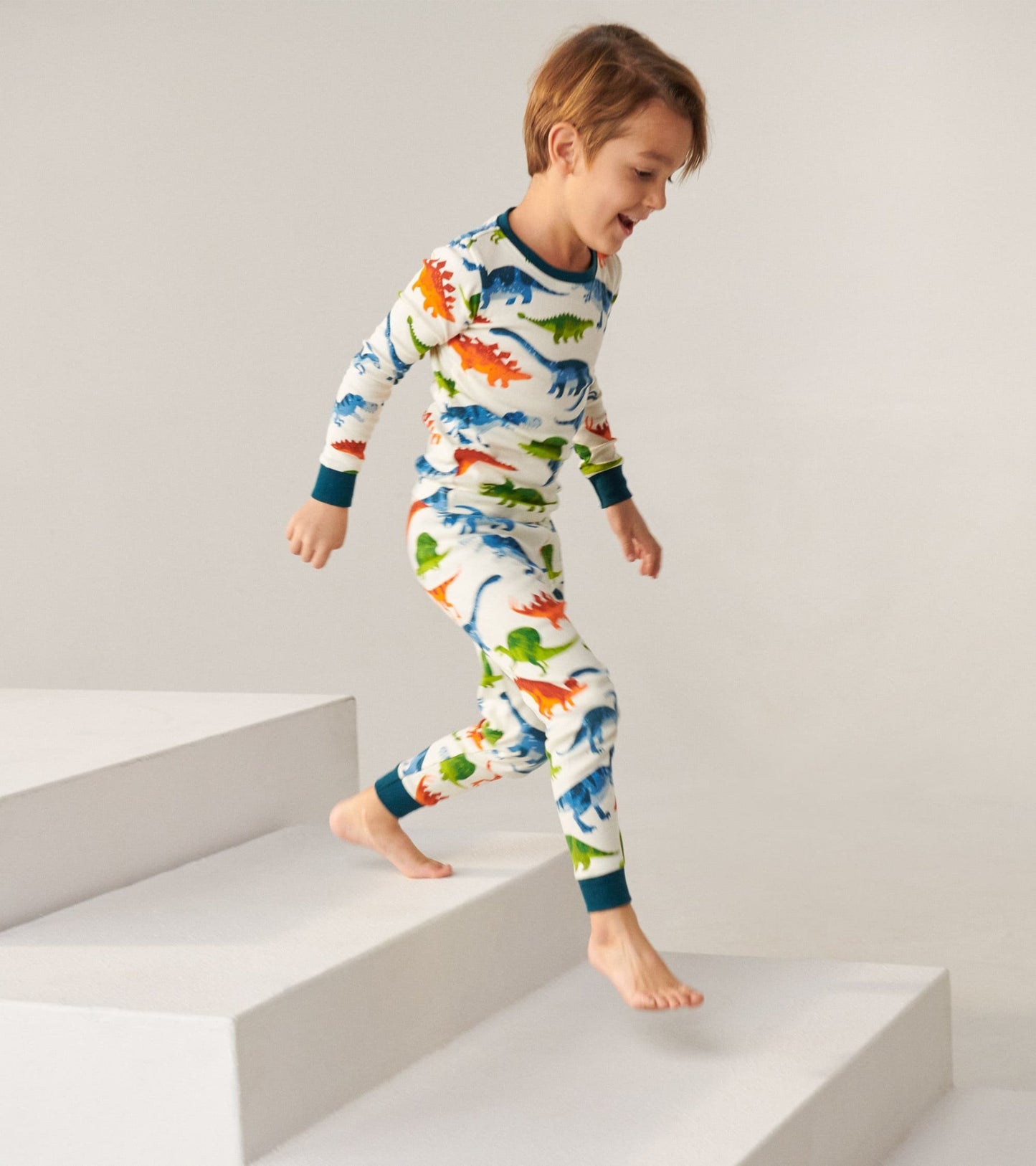 Organic cotton kids pajama set featuring colorful dinosaur patterns, long sleeves, and matching pants, ideal for sleepwear.