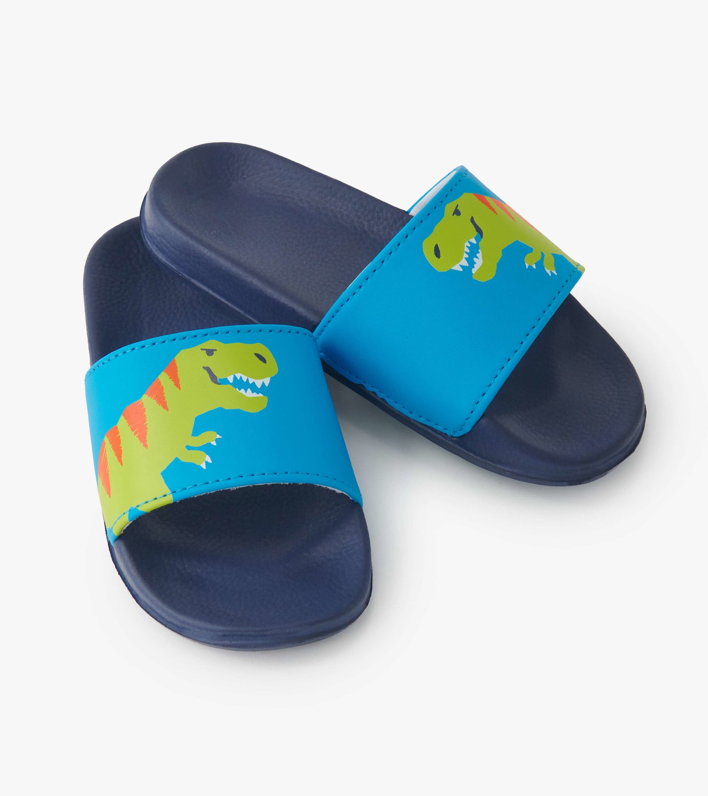 Blue slide-on sandals featuring a green T-Rex graphic and a navy sole, designed for kids.