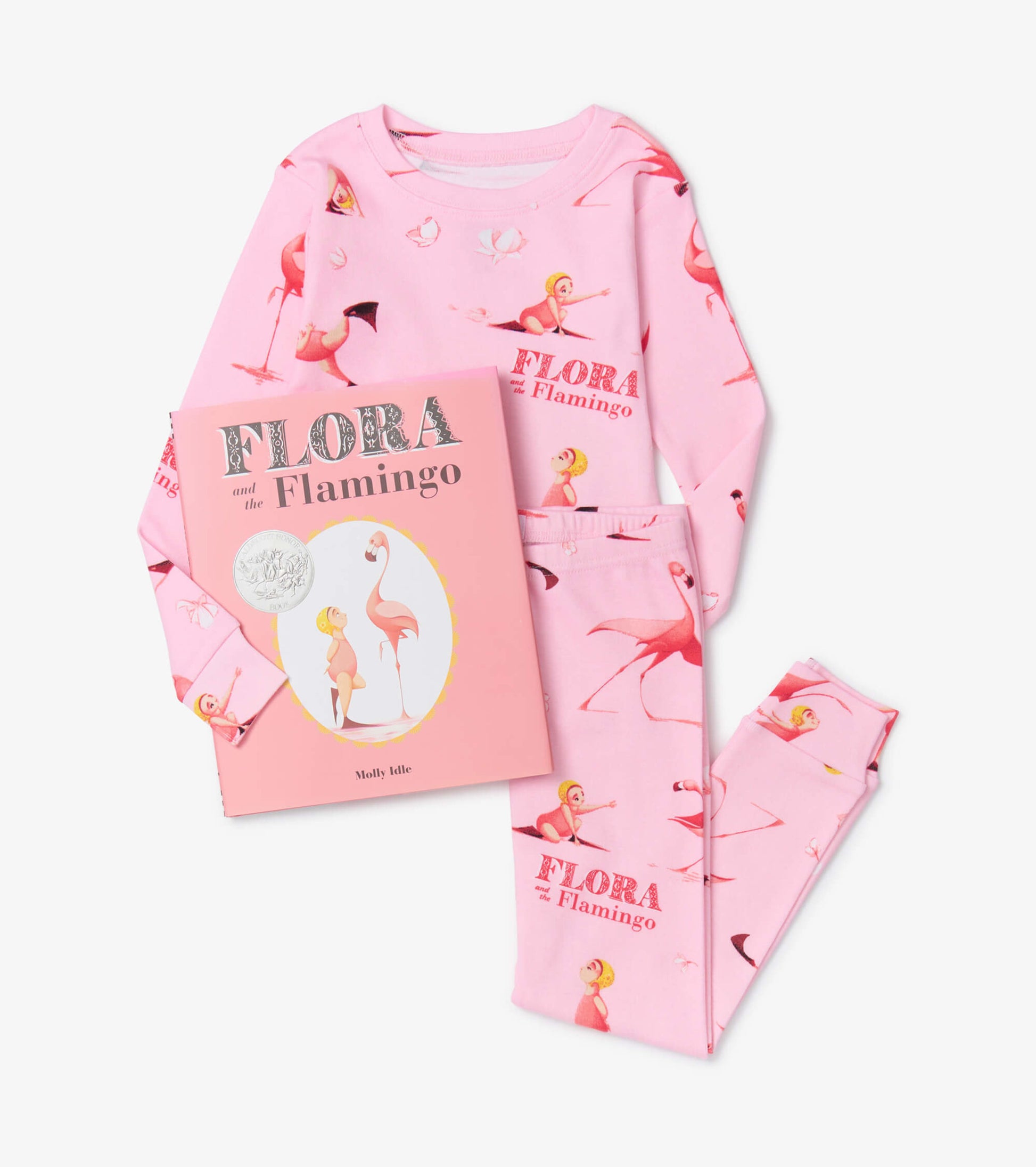 Pink pajama set featuring flamingo and girl illustrations, paired with a matching book titled "Flora and the Flamingo.