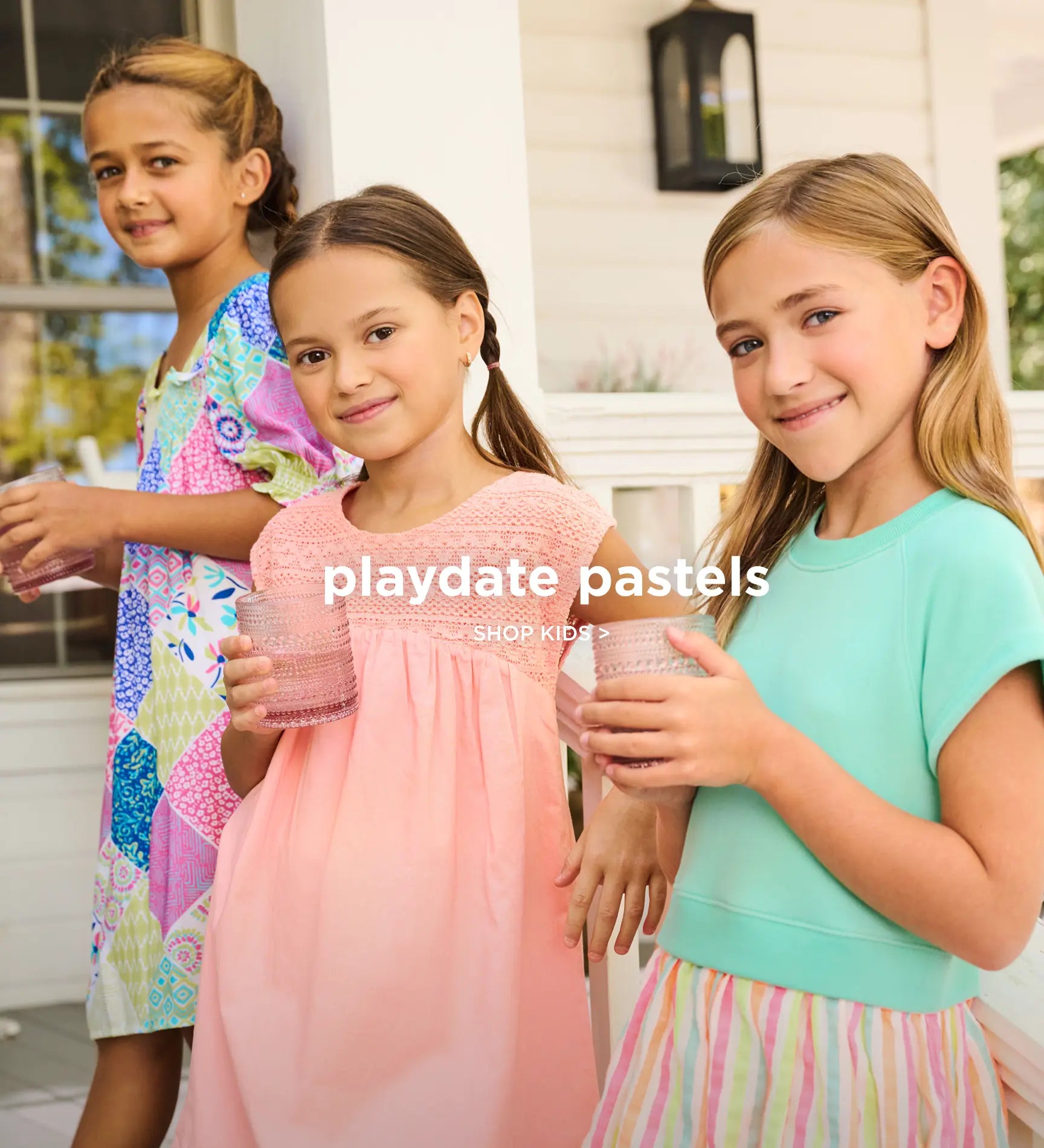 Promotes the kids collection in pastel styles. Showing three girls wearing pastel outfits on a porch.